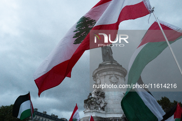 Demonstrators hold Palestinian and Lebanese flags during a gathering called in support of Lebanon, in Paris, France, on September 27, 2024....