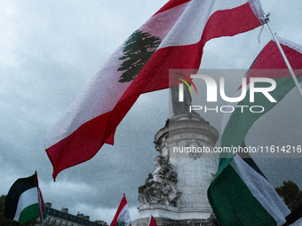 Demonstrators hold Palestinian and Lebanese flags during a gathering called in support of Lebanon, in Paris, France, on September 27, 2024....