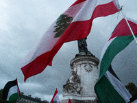 Demonstrators hold Palestinian and Lebanese flags during a gathering called in support of Lebanon, in Paris, France, on September 27, 2024....