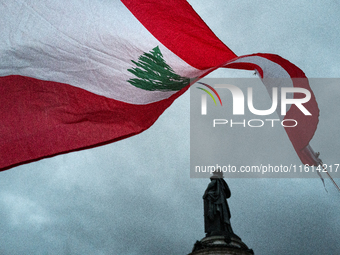 A demonstrator holds a Lebanese flag during a gathering called in support of Lebanon, in Paris, France, on September 27, 2024, in solidarity...