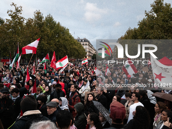 Demonstrators hold Palestinian and Lebanese flags during a gathering called in support of Lebanon, in Paris, France, on September 27, 2024....