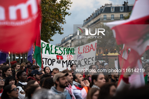 Demonstrators hold Palestinian and Lebanese flags and a banner reading 'Palestine Lebanon, stop the massacres' during a gathering called in...