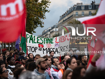 Demonstrators hold Palestinian and Lebanese flags and a banner reading 'Palestine Lebanon, stop the massacres' during a gathering called in...