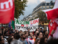 Demonstrators hold Palestinian and Lebanese flags and a banner reading 'Palestine Lebanon, stop the massacres' during a gathering called in...