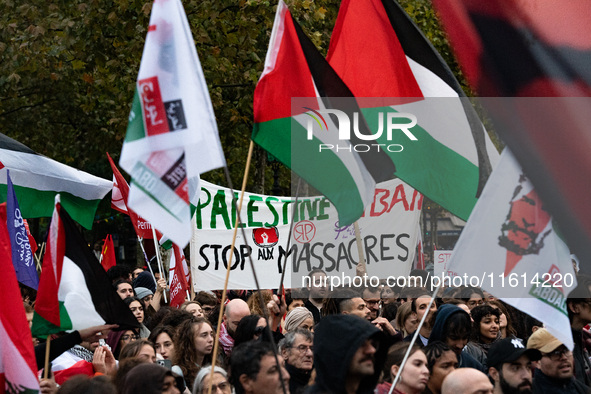 Demonstrators hold Palestinian and Lebanese flags and a banner reading 'Palestine Lebanon, stop the massacres' during a gathering called in...