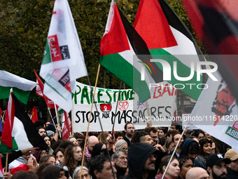 Demonstrators hold Palestinian and Lebanese flags and a banner reading 'Palestine Lebanon, stop the massacres' during a gathering called in...