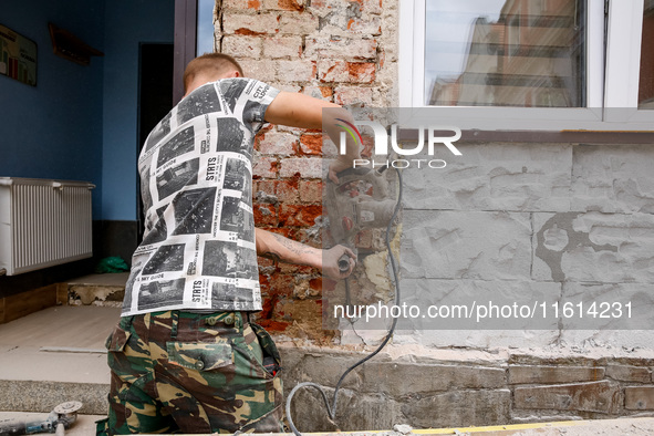 A man removes wet plaster  from affected buildings as massive flooding affected tourist resorts in southern Poland - Ladek Zdroj, Poland on...