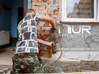 A man removes wet plaster  from affected buildings as massive flooding affected tourist resorts in southern Poland - Ladek Zdroj, Poland on...