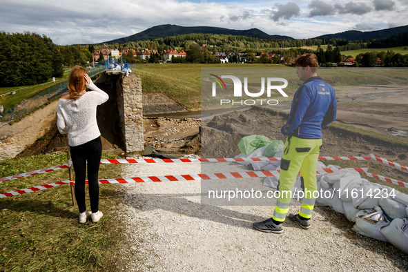 Visitors look at the broken dam that added to the scale of massive flooding in southern Poland is seen in tourist resorts in southern Poland...