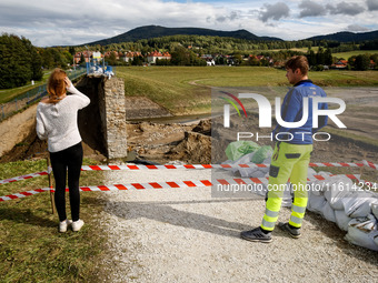 Visitors look at the broken dam that added to the scale of massive flooding in southern Poland is seen in tourist resorts in southern Poland...