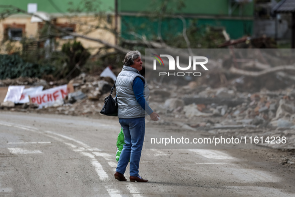 A woman walks pass debris of destroyed  buildings are seen  as massive flooding affected tourist resorts in southern Poland - Stronie Slaski...