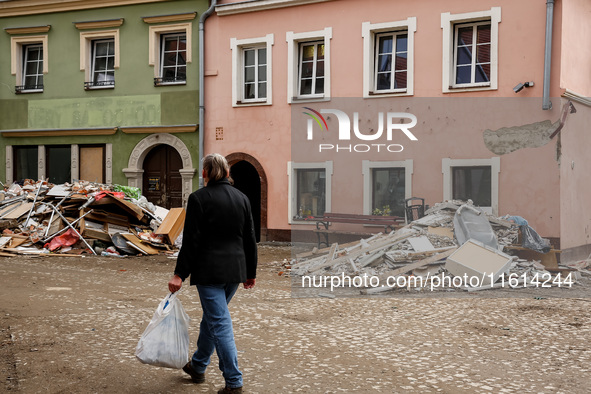 A woman walks pass debris from destroyed  buildings as massive flooding affected tourist resorts in southern Poland - Klodzko, Poland on Sep...