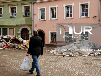 A woman walks pass debris from destroyed  buildings as massive flooding affected tourist resorts in southern Poland - Klodzko, Poland on Sep...