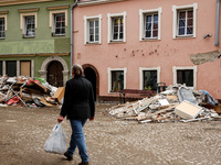 A woman walks pass debris from destroyed  buildings as massive flooding affected tourist resorts in southern Poland - Klodzko, Poland on Sep...