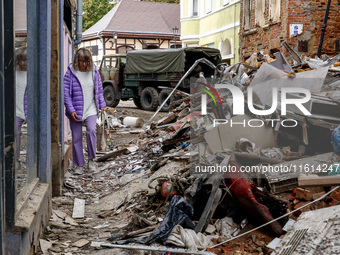 A woman walks pass debris from destroyed  buildings as massive flooding affected tourist resorts in southern Poland - Klodzko, Poland on Sep...