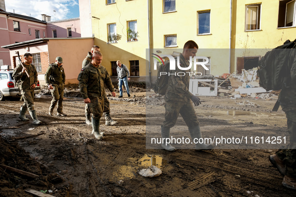 Military servicemen walk pass debris from destroyed  buildings as massive flooding affected tourist resorts in southern Poland - Klodzko, Po...