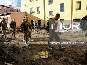 Military servicemen walk pass debris from destroyed  buildings as massive flooding affected tourist resorts in southern Poland - Klodzko, Po...