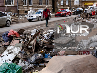 A woman walks pass debris from destroyed  buildings as massive flooding affected tourist resorts in southern Poland - Klodzko, Poland on Sep...