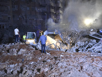 People watch as a blaze rages amid the smoldering rubble of a building destroyed in an Israeli air strike in the Haret Hreik neighborhood of...