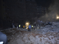 People watch as a blaze rages amid the smoldering rubble of a building destroyed in an Israeli air strike in the Haret Hreik neighborhood of...