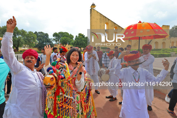 Rajasthani folk artists perform with tourists during the World Tourism Day celebration at the historical Jantar Mantar in Jaipur, Rajasthan,...