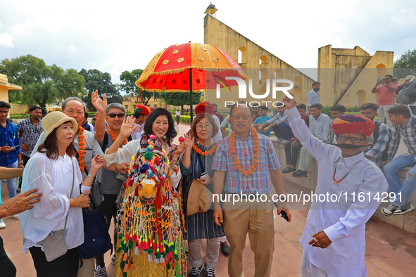 Rajasthani folk artists perform with tourists during the World Tourism Day celebration at the historical Jantar Mantar in Jaipur, Rajasthan,...