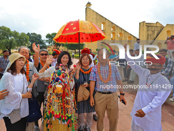 Rajasthani folk artists perform with tourists during the World Tourism Day celebration at the historical Jantar Mantar in Jaipur, Rajasthan,...