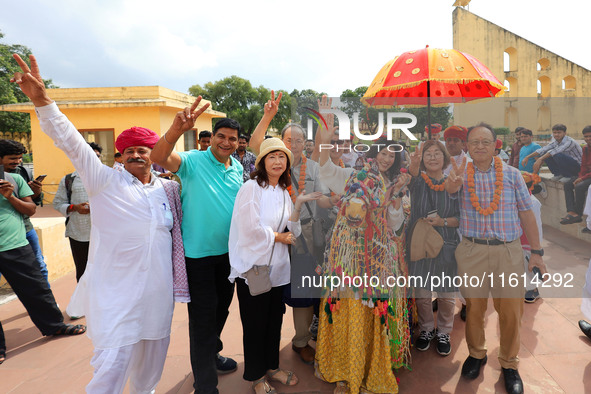 Rajasthani folk artists perform with tourists during the World Tourism Day celebration at the historical Jantar Mantar in Jaipur, Rajasthan,...