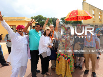 Rajasthani folk artists perform with tourists during the World Tourism Day celebration at the historical Jantar Mantar in Jaipur, Rajasthan,...