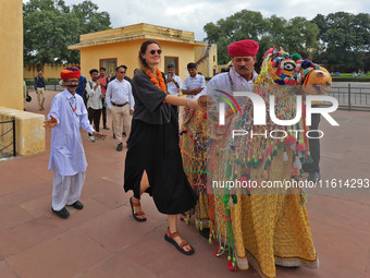 Rajasthani folk artists perform with tourists during the World Tourism Day celebration at the historical Jantar Mantar in Jaipur, Rajasthan,...