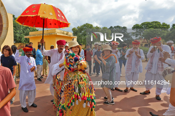 Rajasthani folk artists perform with tourists during the World Tourism Day celebration at the historical Jantar Mantar in Jaipur, Rajasthan,...