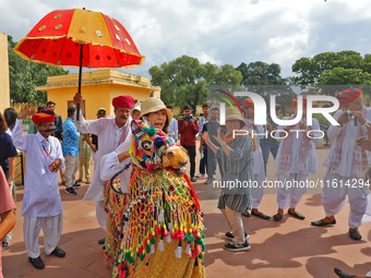 Rajasthani folk artists perform with tourists during the World Tourism Day celebration at the historical Jantar Mantar in Jaipur, Rajasthan,...