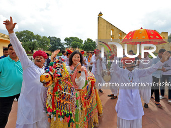 Rajasthani folk artists perform with tourists during the World Tourism Day celebration at the historical Jantar Mantar in Jaipur, Rajasthan,...