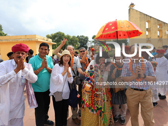 Rajasthani folk artists perform with tourists during the World Tourism Day celebration at the historical Jantar Mantar in Jaipur, Rajasthan,...