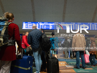 Travelers wait in line in front of the train information desk at Cologne Central Station due to construction work. Cologne Central Station c...