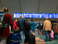 Travelers wait in line in front of the train information desk at Cologne Central Station due to construction work. Cologne Central Station c...