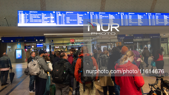 Travelers wait in line in front of the train information desk at Cologne Central Station due to construction work. Cologne Central Station c...