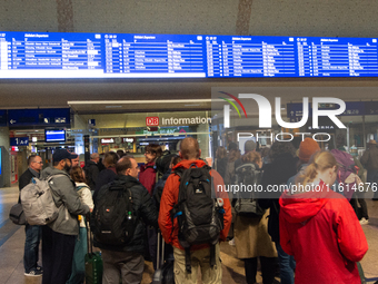 Travelers wait in line in front of the train information desk at Cologne Central Station due to construction work. Cologne Central Station c...