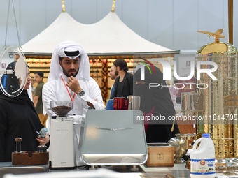 An exhibitor introduces products to visitors at the 2024 Doha International Coffee Exhibition at Doha Exhibition and Convention Center in Do...