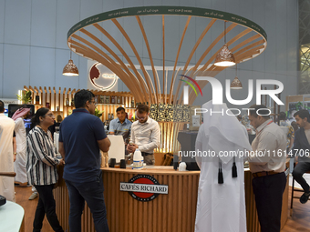 Visitors watch coffee products at a booth during the 2024 Doha International Coffee Exhibition at Doha Exhibition and Convention Center in D...