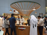 Visitors watch coffee products at a booth during the 2024 Doha International Coffee Exhibition at Doha Exhibition and Convention Center in D...