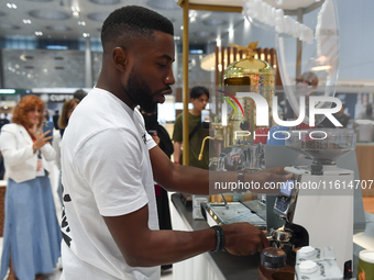 An exhibitor operates a new coffee maker at the 2024 Doha International Coffee Exhibition at Doha Exhibition and Convention Center in Doha,...