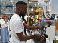 An exhibitor operates a new coffee maker at the 2024 Doha International Coffee Exhibition at Doha Exhibition and Convention Center in Doha,...