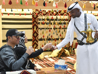 A Qatari man serves traditional Arabic coffee to visitors during the 2024 Doha International Coffee Exhibition at Doha Exhibition and Conven...