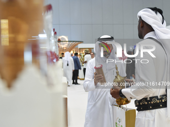 Visitors look at new coffee products during the 2024 Doha International Coffee Exhibition at Doha Exhibition and Convention Center in Doha,...