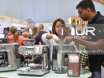 A visitor learns about flavored coffee at the booth at the 2024 Doha International Coffee Exhibition at Doha Exhibition and Convention Cente...