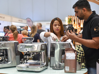 A visitor learns about flavored coffee at the booth at the 2024 Doha International Coffee Exhibition at Doha Exhibition and Convention Cente...