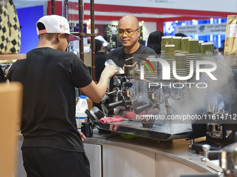 An exhibitor prepares coffee at the 2024 Doha International Coffee Exhibition at Doha Exhibition and Convention Center in Doha, Qatar, on Se...