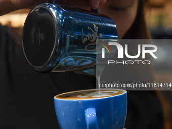 An exhibitor prepares coffee at the 2024 Doha International Coffee Exhibition at Doha Exhibition and Convention Center in Doha, Qatar, on Se...