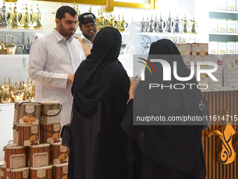 Visitors watch coffee products at a booth during the 2024 Doha International Coffee Exhibition at Doha Exhibition and Convention Center in D...